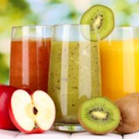 Three glasses of juice along with apple and kiwi