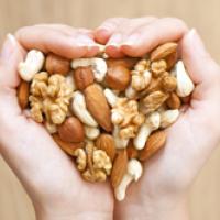 Hands cupped holding a mixture of nuts in a heart shape