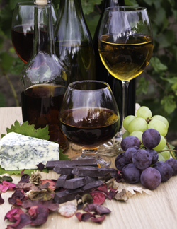 Wine glasses, fruit, chocolate, and vegan cheese display